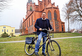 Pastor Bernhard Riedel vor der Kirche in Penkun, die zu den Stationen der deutsch-polnischen Bugenhagen-Radtour gehört, die vom 21. bis 27. August von Treptow an der Rega in die Lutherstadt Wittenberg führt