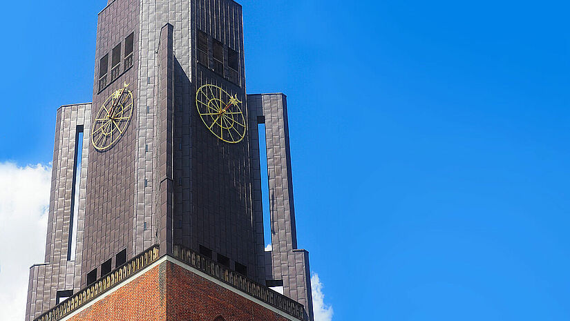 Kirchturm der St. Jacobi Kirche in Hamburg vor blauem Himmel.
