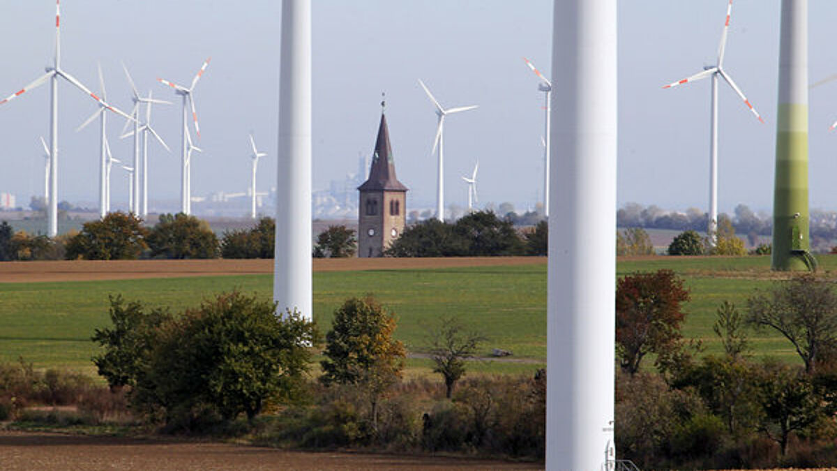Blick auf den Kirchturm und die Windkraftanlage von Arnstedt (Sachsen-Anhalt).