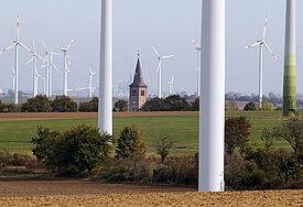 Blick auf den Kirchturm und die Windkraftanlage von Arnstedt (Sachsen-Anhalt)