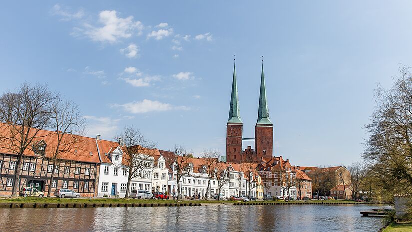 Blick von der Trave auf die aus rotem Backstein erbauten Türme des Lübecker Doms.