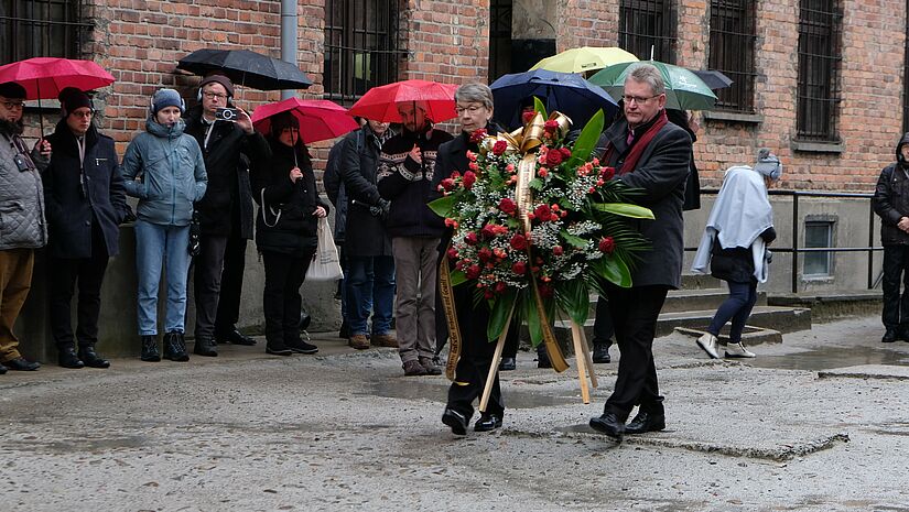 Landesbischöfin Kristina Kühnbaum-Schmidt und Bischof Jerzy Samiec der Evangelisch-Augsburgischen Kirche in Polen legen in Auschwitz-Birkenau einen Kranz nieder.