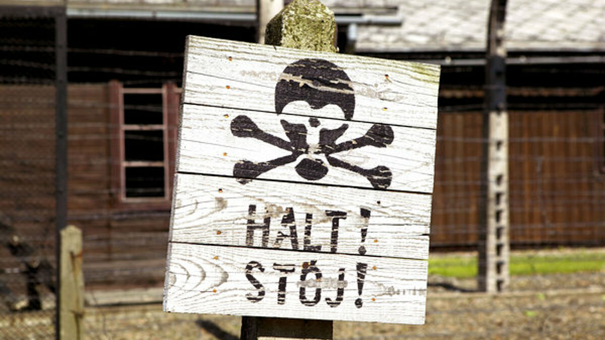 Schild mit Totenkopf am ehemaligen Konzentrationslager Auschwitz-Birkenau in Polen. Am 27.1.1945, wurde das KZ von russischen Truppen befreit.
