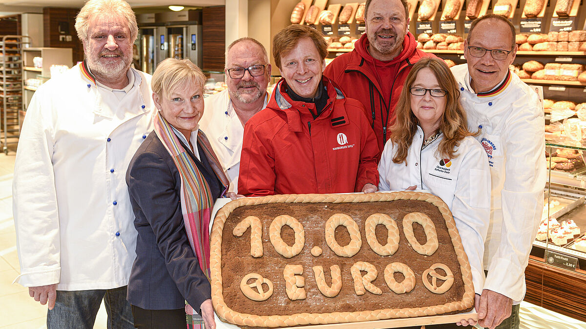 Spendenscheck-Übergabe von Bischöfin Kirsten Fehrs und der Hamburger Bäckerinnung an die Hamburger Tafel am 30.01.2023 in der Rohlfs Bäckerei in HH-Berne.
Von links nach rechts:
Dirk Hansen (stellvertretender Vorsitzender der Bäckerinnung), Bischöfin Kirsten Fehrs, Heinz Hintelmann (Beauftragter für Öffentlichkeitsarbeit der Bäckerinnung), Jan-Henrik Hellwege (Geschäftsführer Hamburger Tafel), Frank Hinrichs (Vorstand Hamburger Tafel), Katharina Daube (Obermeisterin der Bäckerinnung) sowie Hardy Krause (Vorstandsmitglied der Bäckerinnung und Geschäftsführer der Rohlfs Bäckerei)
