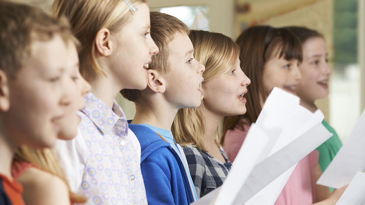 Group Of School Children Singing In School Choir