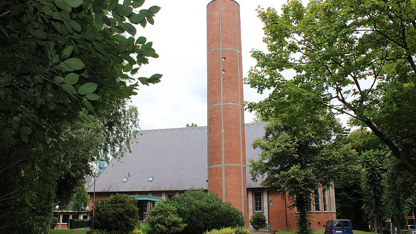 Ein runder Kirchturm aus Backsteinen und Beton