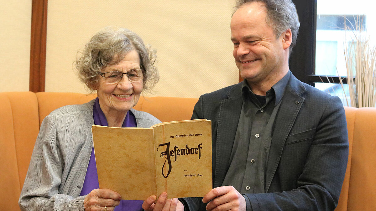 Lotte-Marie Pötter studiert mit Bischof Tilman Jeremias die Ortschronik von Jesendorf.
