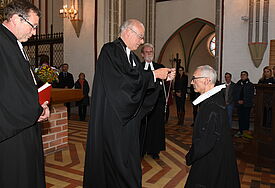 Landesbischof Gerhard Ulrich (Mitte) überreichte Diakoniepastor Paul Philipps (r.) das Amtskreuz im Schweriner Dom.