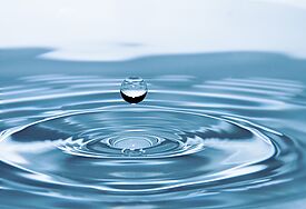 Wassertropfen, der in eine Pfütze fällt