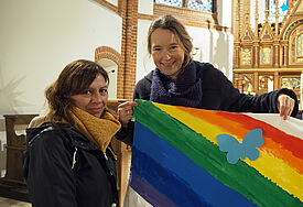 Mutter Daniela Wulff (l.) und Pastorin Mareike Hansen mit dem Regenbogen-Banner, auf dem die Schmetterlinge mit den Namen der verstorbenen Kinder angebracht werden.