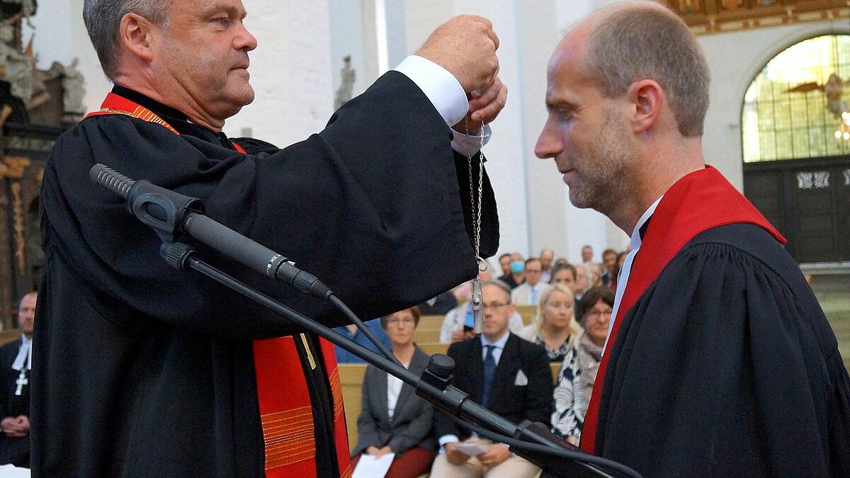 Bischof Jeremias überreicht das Amtskreuz an Propst Tobias Sarx. 