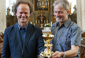 Tilmann Jeremias, Pastor der Rostocker Innenstadtgemeinde, (li.) und Restaurator Thomas Wurm mit dem restaurierten Abendmahlskelch aus dem 15. Jahrhundert (r.) Foto: D.Vogel /kirche-mv.de