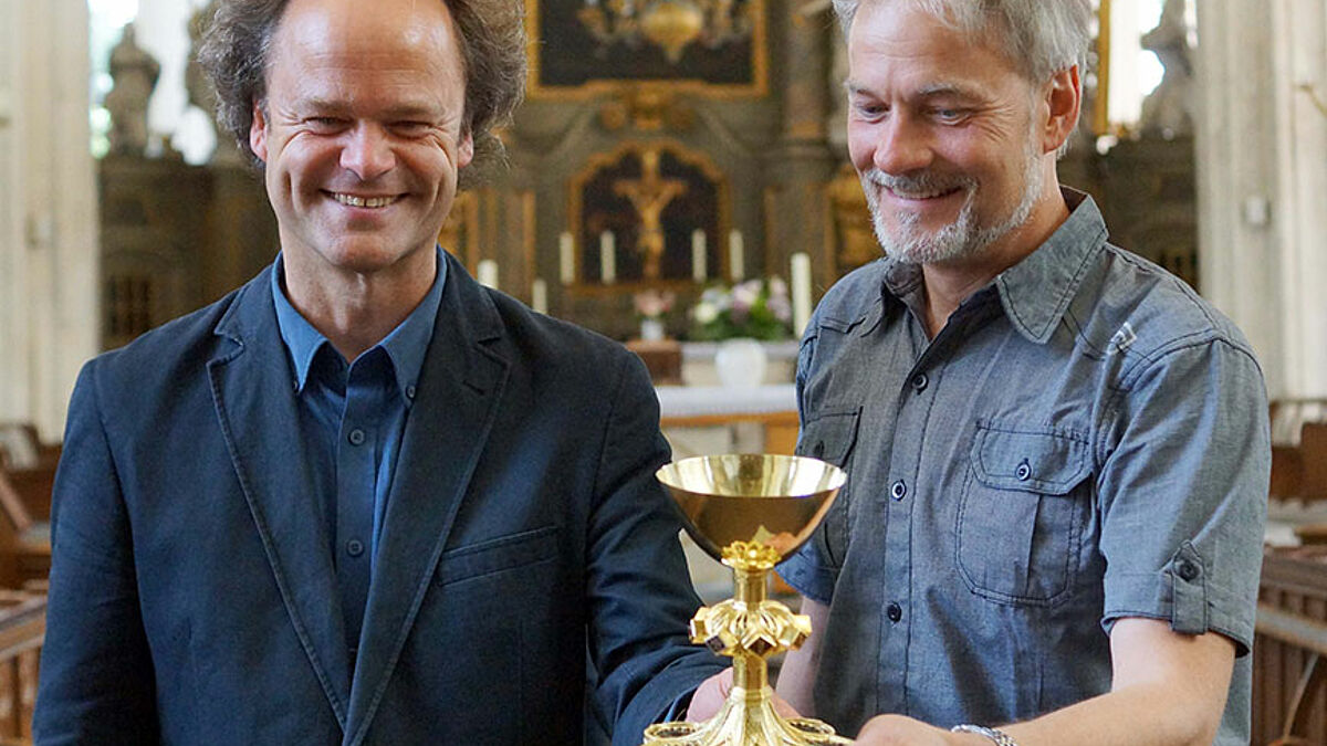 Tilmann Jeremias, Pastor der Rostocker Innenstadtgemeinde, (li.) und Restaurator Thomas Wurm mit dem restaurierten Abendmahlskelch aus dem 15. Jahrhundert