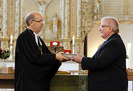 Bischof Magaard überreicht eine revidierte Lutherbibel 2017 im Format einer Altarbibel an Landtagspräsident Schlie für den Raum der Stille im Landtag SH
