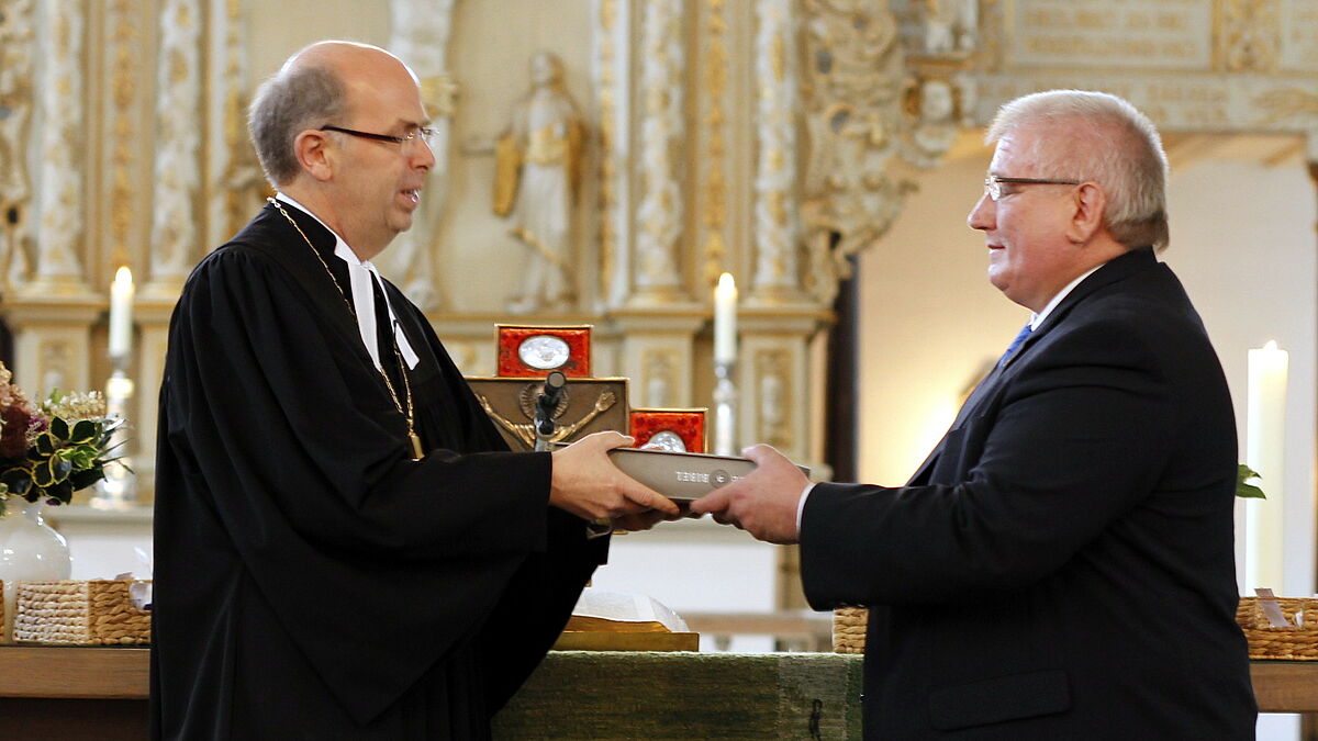 Bischof Magaard überreicht eine revidierte Lutherbibel 2017 im Format einer Altarbibel an Landtagspräsident Schlie für den Raum der Stille im Landtag SH