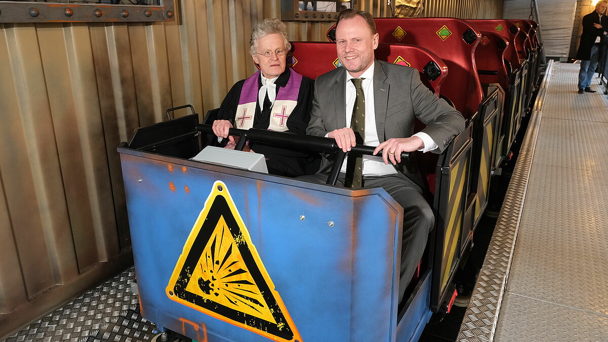 Dom-Pastor Friedrich Brandi (l.) mit Hamburgs Innensenator Andy Grote (SPD) in der neuen Geisterbahn, die der Pastor zur Eröffnung des Frühlingsdoms gesegnet hat.