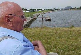 Gerne sitzt Polli Rohwedder an der Seeschleuse in Friedrichskoog uns blickt auf das Meer, nachdem er in der nebean liegenden Seehundstation nach dem Rechten gesehen hat. (c) Maren Warnecke, Evangelische Zeitung