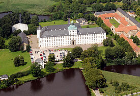 Blick aus der Luft auf das weiße Schloss Gottorf auf der Schleswiger-Museumsinsel.
