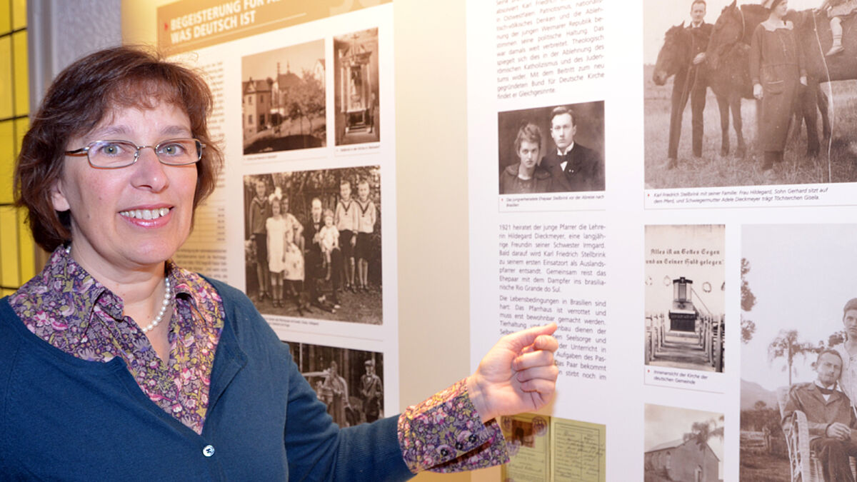 Pastorin Constanze Oldendorf vor Schaubildern der Ausstellung
