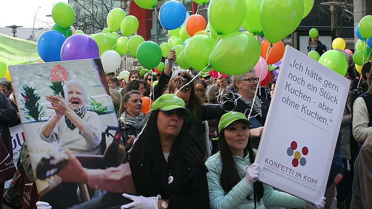 Mit Fotos und humorvollen Zitaten von Demenzkranken warben die Teilnehmer der "Konfetti-Parade" für offene Begegnungen 