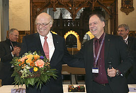 Der Präses der Synode, Andreas Tietze (rechts), gratuliert Gerhard Ulrich zur Wahl zum ersten Landesbischof der Nordkirche (c) epd-bild/Stephan Wallocha