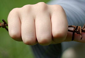 Hand am Stacheldrahtzaun