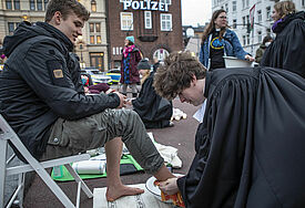 Der 28-jährige Pastor Jakob Pape von der St. Andreas Kirche im Grindel/Havestehude in Hamburg wäscht dem 18-jährigen Moritz Eigenauer aus Rostock, der zum Feiern auf die Reeperbahn kam, die Füße.