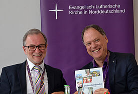 Präses Dr. Andreas Tietze erhielt die neue Broschüre des Zentrums für Ökumene und Mission - nordkirche weltweit von Direktor Dr. Klaus Schäfer aus der Synoden-Pressekonferenz