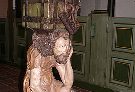 Der 400 Jahre alte Opferstock der St. Johanneskirche zu Seester – ein vom Leid gebeugter "Armer Lazarus" trägt den Kasten auf seinem Kreuz.