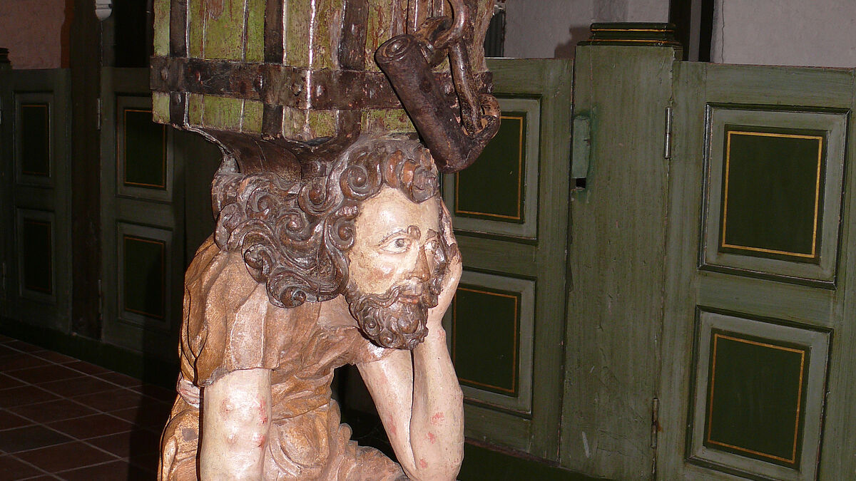 Der 400 Jahre alte Opferstock der St. Johanneskirche zu Seester – ein vom Leid gebeugter "Armer Lazarus" trägt den Kasten auf seinem Kreuz.