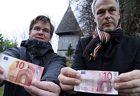 Zehn Euro Startkapital, präsentiert von Pastor Jörg Jackisch (li.) und Lutz Tschense, dem Vorsitzenden des Kirchbauvereins
