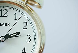 Angeschnittenes Ziffernblatt einer Uhr mit Zahlen und Zeigern