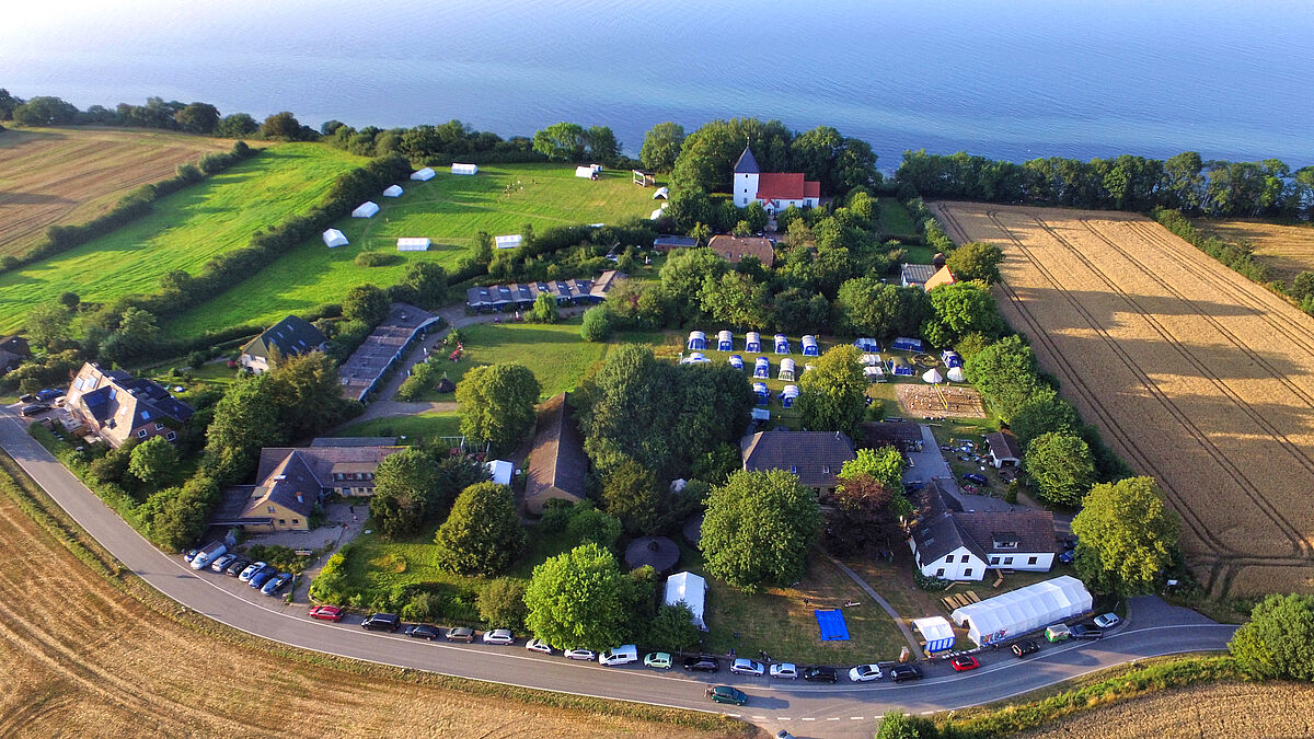 Die Gäste- und Seminarhäuser auf dem Gelände des Kirchbergs Neukirchen liegen 250 m oberhalb des Naturstrandesdirekt an der Flensburger Förde.