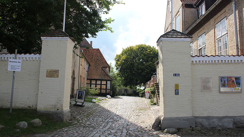 Durchgang durch eine mauer auf das Klostergelände mit zwei dicken Mauerpfeilern rechts und links
