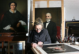 Die Restauratorin Ewa Gilún in der Denkmalwerkstatt der Hauptkirche St. Jacobi bearbeitet das Portrait von Betty Heine, Tante des Dichters Heinrich Heine. Links Esther Edvards, rechts Louis Wolf, Vorstand der Jüdischen Gemeinde Wandsbek.