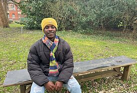 FOEJ Justice aus Ghana in seiner Einsatzstelle in Kiel auf einer Bank